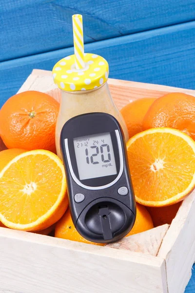 Glucometer with sugar level and coctail or smoothie from citrus fruits. Diabetes and healthy snack containing minerals and vitamins