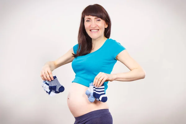 Donna incinta con calzini per bambino, in attesa per il bambino — Foto Stock