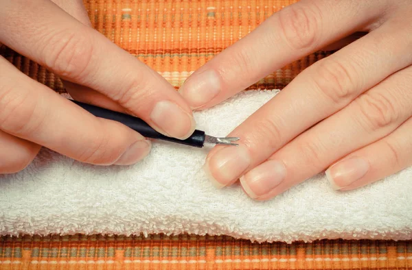 Woman trimming cuticles of hand. Care of hands concept