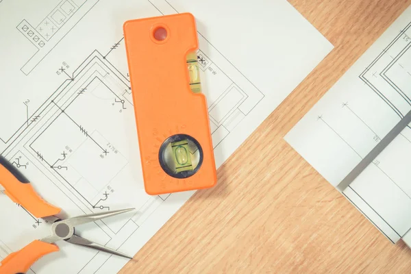 Planos ou diagramas eléctricos e ferramentas de trabalho cor-de-laranja para utilização em trabalhos de engenharia — Fotografia de Stock