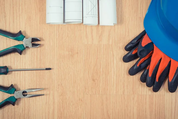 Ролики электрических схем или чертежей, защитный шлем с перчатками и рабочими инструментами, аксессуары для инженерных работ — стоковое фото