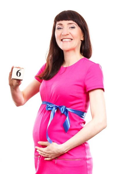 Gravid kvinna visar antalet sjätte månaden av graviditeten, begreppet förväntar sig för nyfödda — Stockfoto