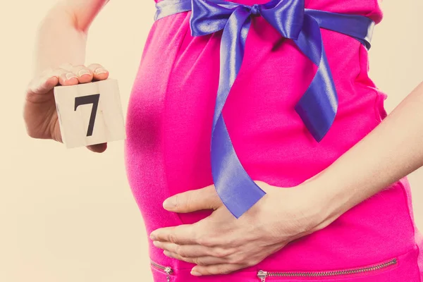 Вінтажне фото, рука жінки, що показує число сьомого місяця вагітності, очікуючи новонародженої концепції — стокове фото