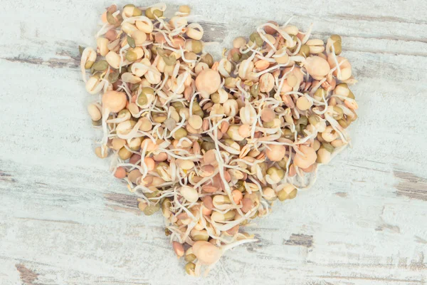 Čerstvá zdravá čočka a cizrna klíčí ve tvaru srdce. Potraviny obsahující přírodní vitamíny a minerály — Stock fotografie