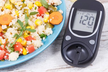 Şeker seviyesini ölçmek için glukometre ve kuskus ve sebzeli salata diyabet, diyet ve zayıflatma için en iyi besleyici gıda olarak