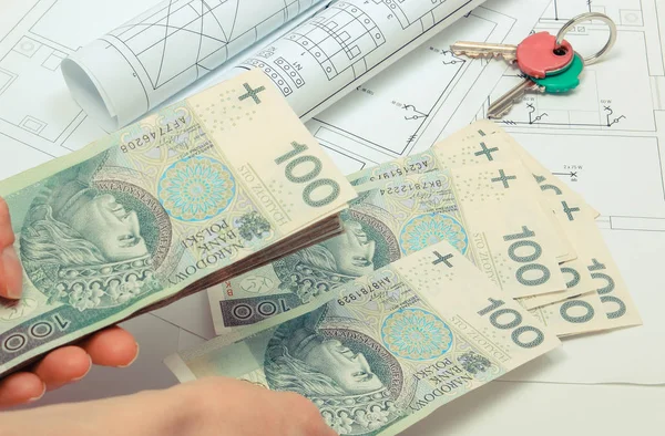 Hand van de vrouw met geld en huissleutels op elektrische constructie tekening van huis. Betaling voor het werkconcept — Stockfoto