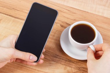 Boş ekran cep telefonu, kahve dokunmadan kadının el
