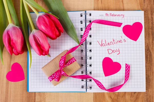 День святого Валентина, написаний у записнику, свіжі тюльпани, обгорнутий подарунком і серцями. Цінування Валентинів — стокове фото