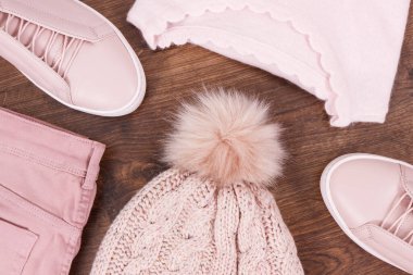 Womanly shoes and clothing on rustic board