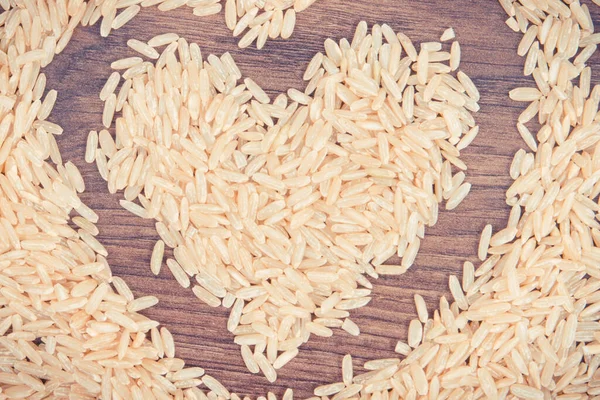 Stare zdjęcie, Serce w kształcie brązowego ryżu na desce rustykalnej — Zdjęcie stockowe