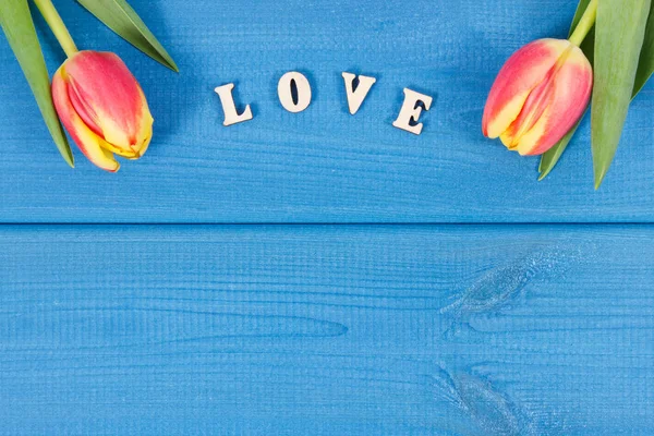 Palabra de amor y tulipanes como sorpresa para San Valentín, cumpleaños u otras ocasiones, lugar para el texto — Foto de Stock