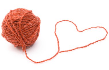 Örgü işi için yün topu ve beyaz arkaplanda kalp şekli