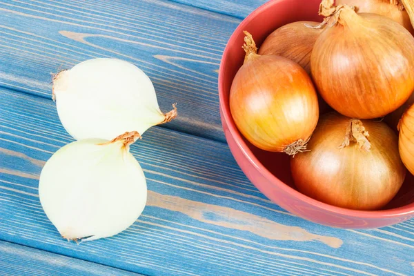 Frische Zwiebeln in Schale auf Brettern liegend, gesundes Ernährungskonzept — Stockfoto