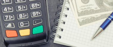 Ödeme terminali, not defteri ve para birimi doları. İş ve finans kavramı