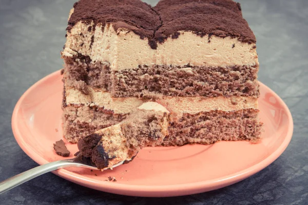 Tasty creamy tiramisu cake on glass plate. Delicious dessert for different occasions