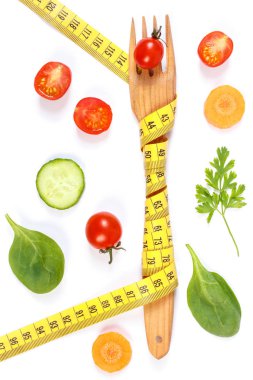 Ahşap çatal sarılmış santimetre ve taze sebze beyaz zemin üzerine, zayıflama kavramı ve sağlıklı beslenme