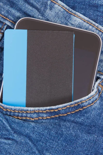 信用卡和智能手机在前牛仔裤口袋 无现金支付的概念 — 图库照片