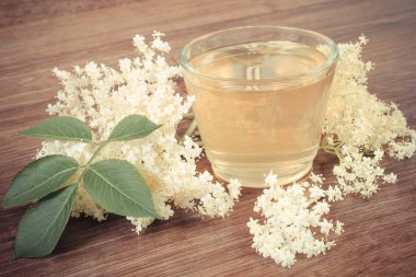 Vintage fotoğraf, bir bardak içecek sağlıklı meyve suyu ve kır panosundaki mürver çiçekleri, alternatif tıp ve terapi