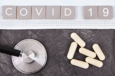 Üzerinde cerrahi veya koruyucu maske, tablet ve stetoskop bulunan Covid-19 yazıyor. Romantik koronavirüs salgını. 2019-NCoV. Sars-CoV-2