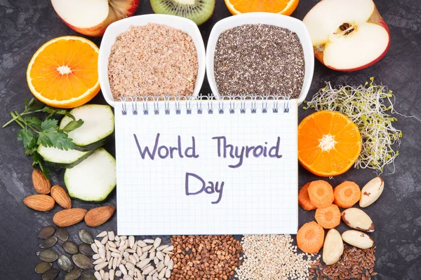 Notepad with inscription World Thyroid Day and best food containing natural minerals and vitamins for healthy thyroid