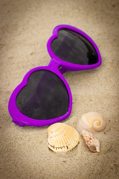 Óculos Sol Roxos Engraçados Forma Coração Conchas Deitadas Areia Praia — Fotografia de Stock
