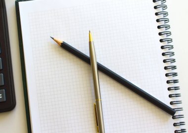 Not defterindeki kalem ve hesap makinesi beyaz arkaplanda izole edildi