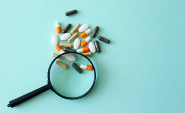 İnceleme altındaki haplar. İlaç, ilaç, vitamin, eczane, büyüteç, konsept
