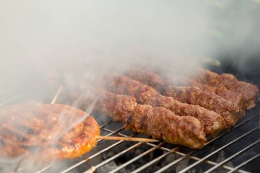 Sosisler ve mici veya mititei adı verilen geleneksel Romen sosisleri (et ve baharat karışımından silindirik şeklinde ızgara et rulolarından oluşan yemek) dumanlı barbekü üzerine