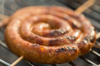 Sosisler ve mici veya mititei adı verilen geleneksel Romen sosisleri (et ve baharat karışımından silindirik şeklinde ızgara et rulolarından oluşan yemek) dumanlı barbekü üzerine