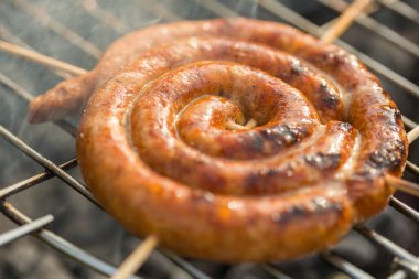 Sosisler ve mici veya mititei adı verilen geleneksel Romen sosisleri (et ve baharat karışımından silindirik şeklinde ızgara et rulolarından oluşan yemek) dumanlı barbekü üzerine