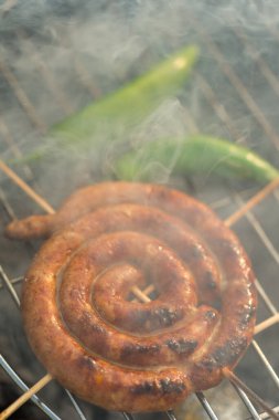 Sosisler ve mici veya mititei adı verilen geleneksel Romen sosisleri (et ve baharat karışımından silindirik şeklinde ızgara et rulolarından oluşan yemek) dumanlı barbekü üzerine