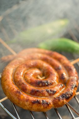 Sosisler ve mici veya mititei adı verilen geleneksel Romen sosisleri (et ve baharat karışımından silindirik şeklinde ızgara et rulolarından oluşan yemek) dumanlı barbekü üzerine