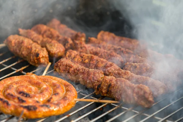 Sosisler ve mici veya mititei adı verilen geleneksel Romen sosisleri (et ve baharat karışımından silindirik şeklinde ızgara et rulolarından oluşan yemek) dumanlı barbekü üzerine
