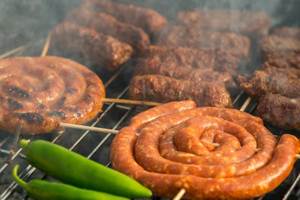 Sosisler ve mici veya mititei adı verilen geleneksel Romen sosisleri (et ve baharat karışımından silindirik şeklinde ızgara et rulolarından oluşan yemek) dumanlı barbekü üzerine