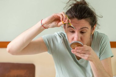 Koronavirüs salgını yüzünden kaşlarını makasla kesen bir kız..