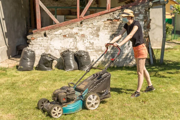 Une Femme Dans Son Jardin Fauchant Herbe Avec Une Tondeuse Images De Stock Libres De Droits