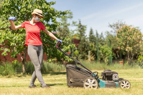 Une Femme Dans Son Jardin Fauchant Herbe Avec Une Tondeuse Images De Stock Libres De Droits