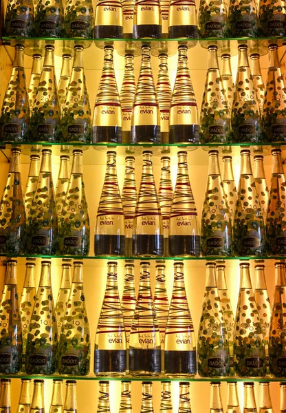 Ряды популярной бутилированной воды на подсветке полки — стоковое фото