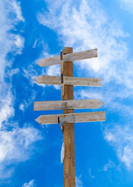 Seta de madeira velha Signpost contra o céu azul nublado — Fotografia de Stock