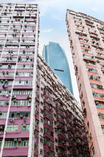 Сучасному хмарочосі піднімається вище старих будівель у Гонконгу — стокове фото