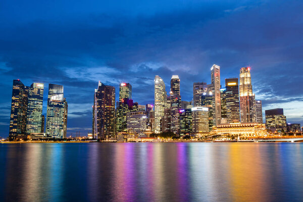 Singapore skyline at Marina Bay during sunset blue hour showing skyscrapers in downtown central financial business district.