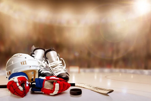 Casco de hockey sobre hielo, patines, guantes, palo y pato en pista — Foto de Stock