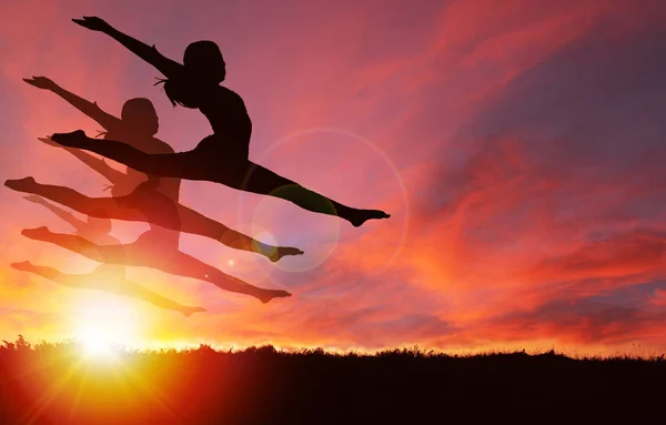女の子の踊りと鮮やかな黄金日の出や日没の背景とコピー スペース ジャンプのシルエット 健康的な生活 お祝いや歓喜の気分のコンセプト — ストック写真