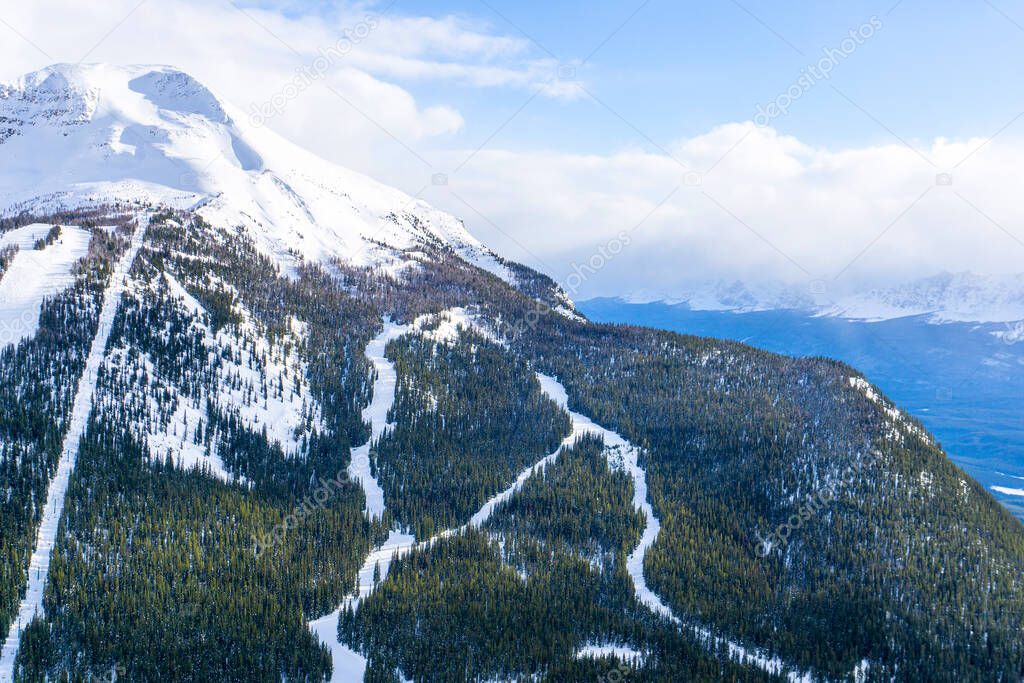 High angle view of ski trails on snow-capped mountain landscape in the Canadian Rockies at Lake Louise near Banff National Park.