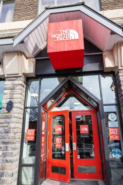 BANFF, CANADA - FEB 15, 2020 : Famous American outdoor recreation retailer The North Face shop with its sign on busy Banff Avenue in Alberta, Canada. The North Face is a ski and outdoor gear shop  specializing in high end outdoor apparel.