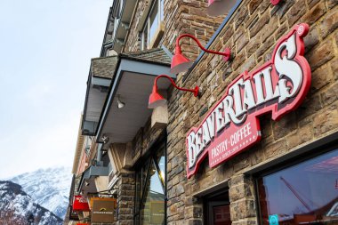BANFF, CANADA - FEB 15, 2020 : Famous Canadian-based BeaverTails restaurant with its sign on busy Banff Avenue in Alberta, Canada.
