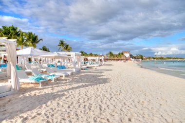 Meksika, Cancun 'daki Karayipler sahilinde güneşli, kumlu bir plajda sıralar dolusu yatak ve sandalye. Yaz tatili ya da kış tatili eğlencesi kavramı.