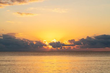 Meksika, Cancun 'da Riviera Maya kıyılarında görüldüğü gibi Karayip Denizi üzerinde bulutlardan doğan altın gün doğumu.