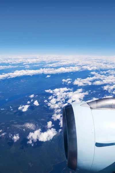 从飞机窗口看到的是云层上的飞机引擎 纵向方向 — 图库照片
