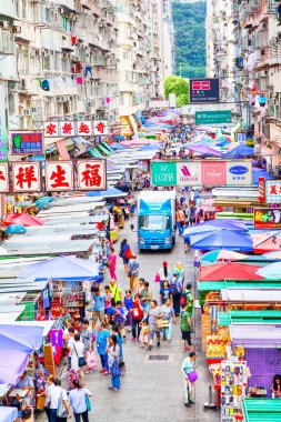 Hong Kong, Hong Kong SAR - 10 Temmuz 2017: Hong Kong 'daki eski kalabalık apartman dairelerinin altındaki Fa Yuen sokak pazarında müşteriler. Bölge, ucuz yemekleri ve moda kıyafetleriyle turistler ve yerel halk arasında popülerdir. Dikey yönelim.